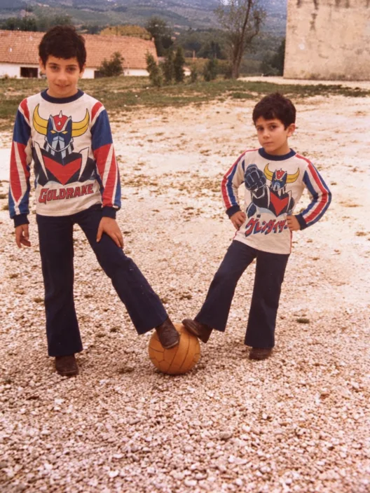 Due bambini con le magliette di Goldrake in un cortile di campagna, fine anni Settanta