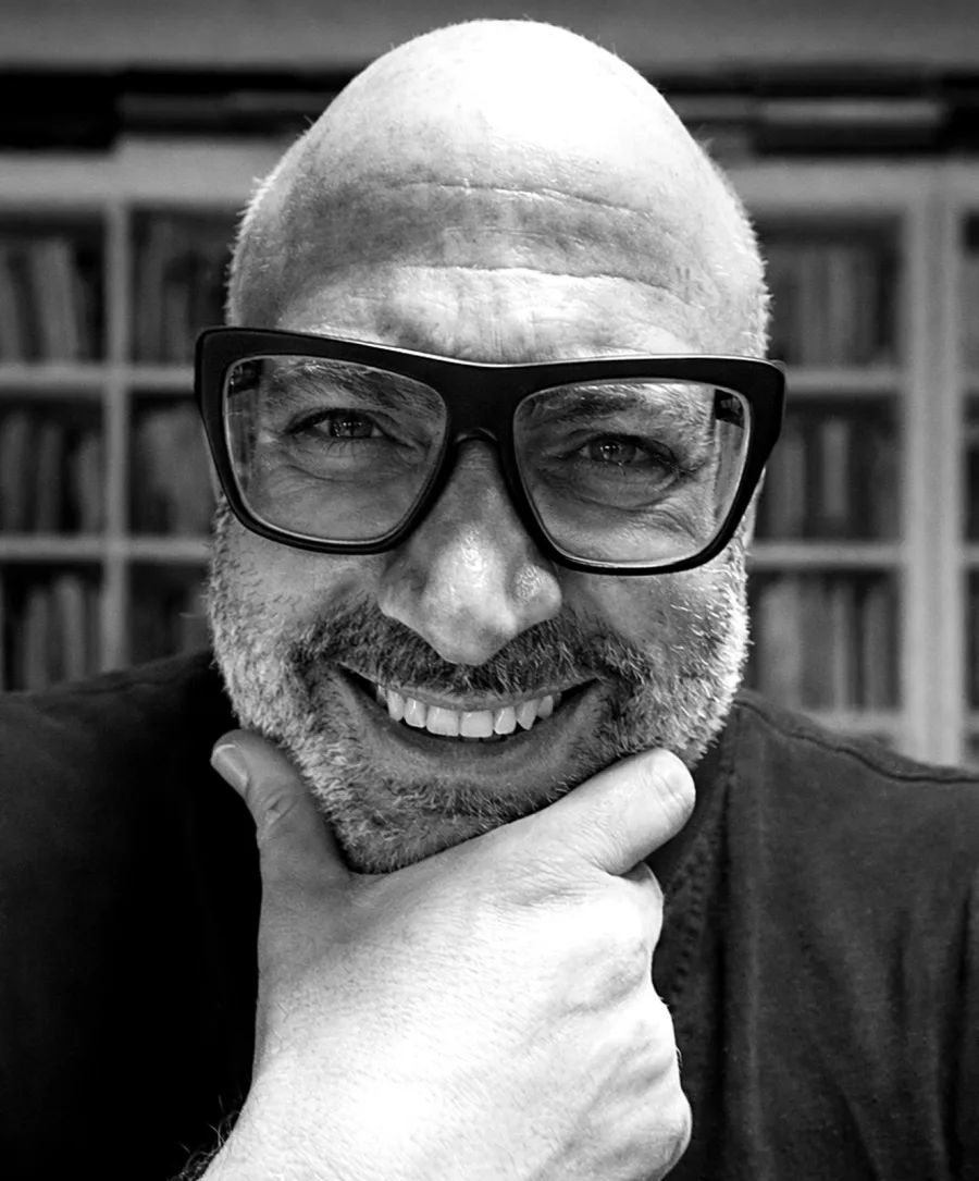 Gabriele Micozzi, ritratto in bianco e nero davanti alla sua libreria