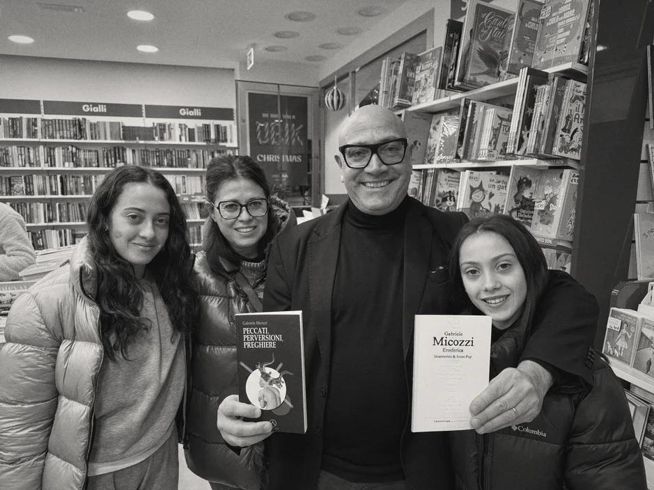 Gabriele Micozzi in libreria con tre lettrici che tengono in mano i suoi libri