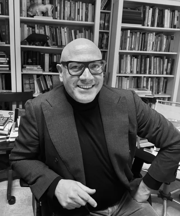 Gabriele Micozzi, ritratto in bianco e nero davanti alla sua libreria